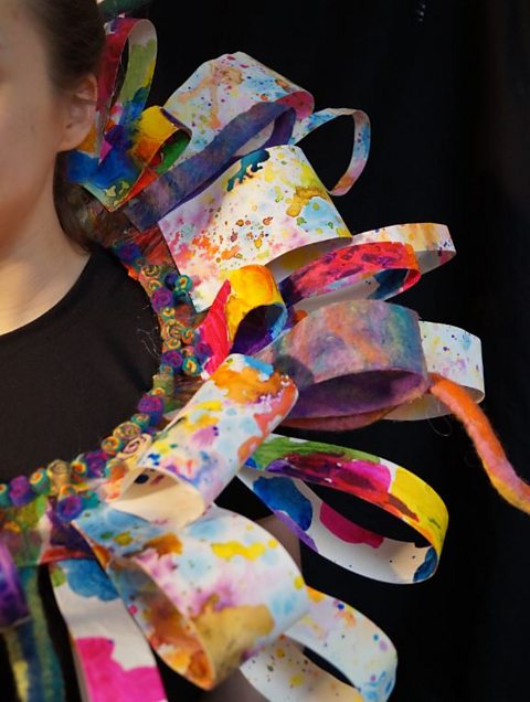 Detail of body adornment neckpiece made from painted loops of card