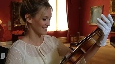Clemency Burton-Hill holds a ‘Strad’ during her documentary on the violin-maker Stradivari (Credit: BBC)