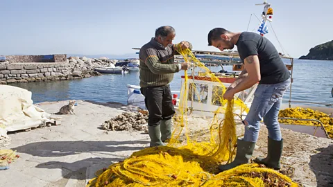 Christian Science Monitor/Getty Images Fisherman Stratis Valiamos (right) uses his boat to rescue refugees from the Aegean (Credit: Christian Science Monitor/Getty Images)