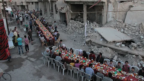 Hamza Al-Ajweh/AFP/Getty Images Residents of the Syrian rebel-held town of Douma broke their Ramadan fast with the ‘iftar’ meal on a heavily damaged street this week (Credit: Hamza Al-Ajweh/AFP/Getty Images)