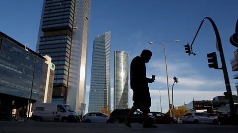 Getty Images A man begs for food outside a financial district in Madrid (Credit: Getty Images)