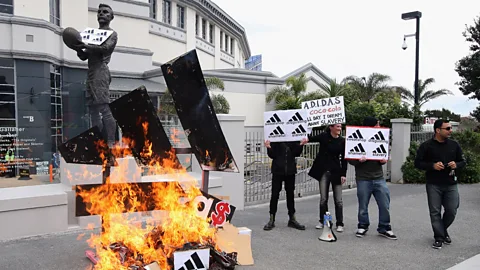 Getty Images A group of activists protest the price Adidas were charging New Zealanders for the All Black rugby jersey in 2011 (Credit: Getty Images)