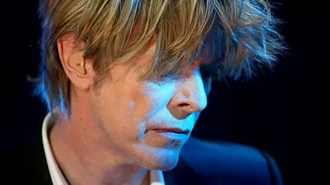 EPA/Fabrice Coffrini Later in his career, Bowie (performing here in 2002 at the Montreux Jazz Festival) wore darker, less distinctive clothes in a bid to go unnoticed (Credit: EPA/Fabrice Coffrini)