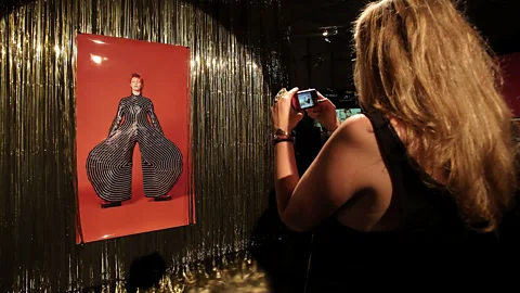 Hannelore Foerster/Getty Images A visitor takes a photo of Bowie (in a Kansai Yamamoto bodysuit for his 1973 Aladdin Sane tour) at ‘GLAM! The Performance of Style' in Frankfurt (Credit: Hannelore Foerster/Getty)