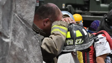 Getty Images A rescue worker leans on his helmet during the effort of clearing rubble and debris to search for survivors (Credit: Getty Images)