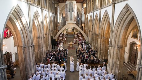 Clergy, choir and congregation under the large concrete arch in the nave of Llandaff Cathedral during a service