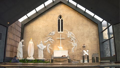 Statues of Our Lady, St Joseph, St John and Lamb of God on an altar with angels