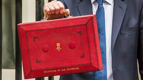 The Chancellor holds up a red box