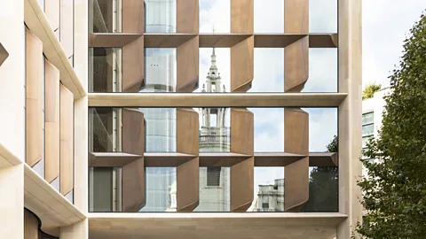 Nigel Young/Foster + Partners Christopher Wren's St Stephen Walbrook is reflected by the façade, a deep stone frame with serrated glass and bronze 'gills' that ventilate (Credit: Nigel Young/Foster + Partners)