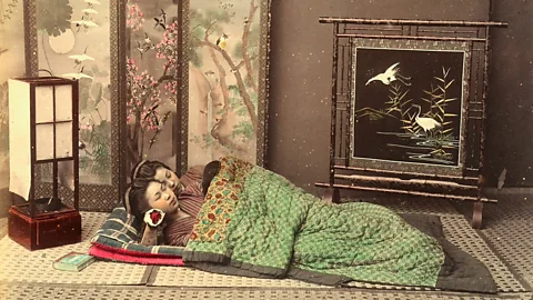 Alinari via Getty Images Two Japanese girls sleep on the floor of a bedroom with typical Japanese furnishings, in an image taken in the late 19th Century (Credit: Alinari via Getty Images)