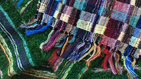 The Monastery scarf uses 'doublecloth' structures woven with cotton chenille, and helped inspire the designers' rectinilinear 'moquette' designs