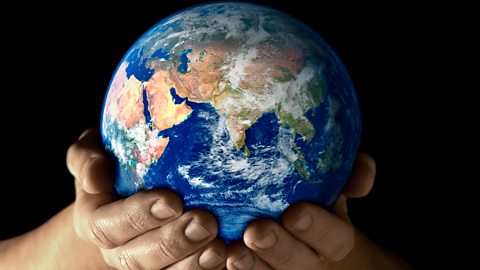 Photograph of a globe being held in hands.