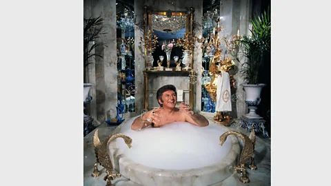 Getty Images From the 1960s, bathrooms became more of a place to display status - Liberace is pictured here bathing in his own $55,000 marble bathtub (Credit: Getty Images)