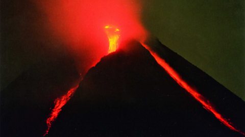 Volcanic eruption of Mount Merapi in Java, Indonesia. Lava can be seen flowing down the side of the mountain.