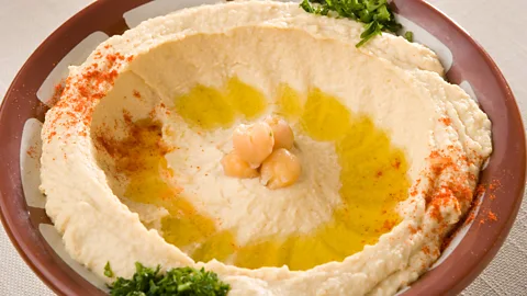 tadphoto/Getty Images Hummus is traditionally served in a red clay bowl with a raised edge (Credit: tadphoto/Getty Images)