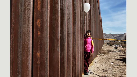 Getty Images A girl holds a balloon at the wall between Mexico and the US in Ciudad Juárez, on the day that families separated by the wall are reunited for three minutes (Credit: Getty Images)