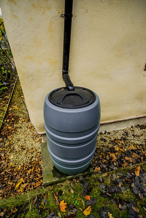 A drain pipe connecting to a plastic structure similar to a bucket with a lid