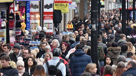 Very large crowds packed into a busy shopping street