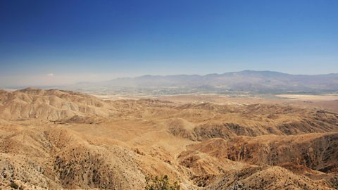 A vast mountainous landscape under a clear blue sky