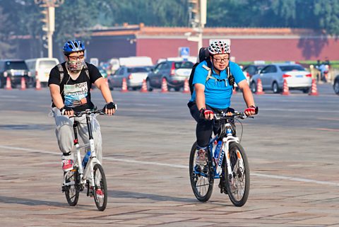 Two overweight cyclists commuting in Beijing