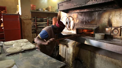 Chris Griffiths Chefs rotate madfouna orders in the large fire ovens (Credit: Chris Griffiths)