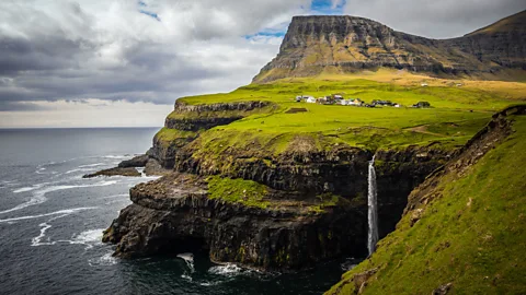 Lola Akinmade Åkerström The village of Gásadalur overlooks the iconic Mulafossur Waterfall in the Faroe Islands (Credit: Lola Akinmade Åkerström)