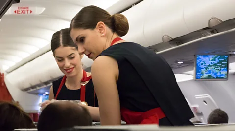 Getty Images Aircrew are often expected to maintain full make-up and an immaculate hairstyle throughout their entire shift even during a night flight service (Credit: Getty Images)