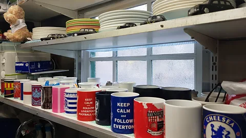 Ella Buchan In the Warwick Avenue shelter, shelves are lined with cabbies’ mugs bearing the names of their football teams (Credit: Ella Buchan)