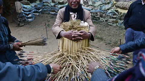 ROBERTO SCHMIDT/Getty Images Gamblers place bets based on how many arrows will hit the target; if the last two digits match their number, they win (Credit: ROBERTO SCHMIDT/Getty Images)