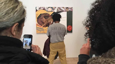 Twitter/ does not wish to be identified Artist Parker Bright protested Dana Schutz’s stylised take on US lynching victim Emmett Till by obstructing view of it (Credit: Twitter/ does not wish to be identified)