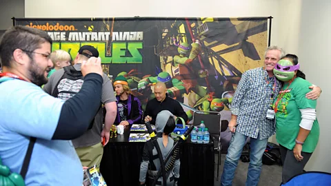 Getty Images Rob Paulsen poses with a fan at a convention. He voiced Raphael in the original Teenage Mutant Ninja Turtles and Donatello in the recent remake (Credit: Getty Images)