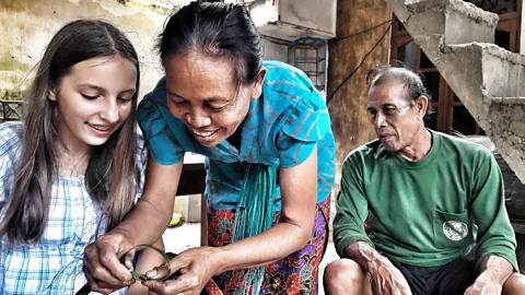 Mark Eveleigh Ketut teaches the author’s daughter to prepare ketupat, tiny woven baskets filled with rice (Credit: Mark Eveleigh)