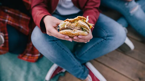 Getty Images Woman eating burger (Credit: Getty Images)