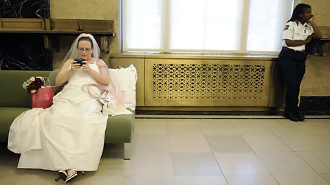 Getty Images A bride checks her email while waiting to marry (Credit: Getty Images)