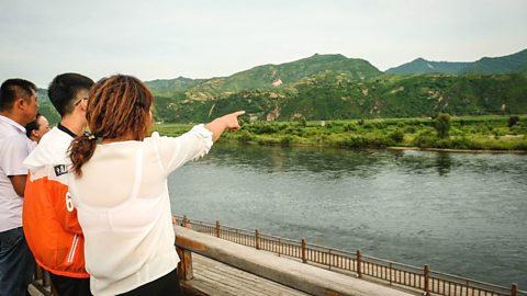 Chinese tourists look across the Yalu river border into North Korea