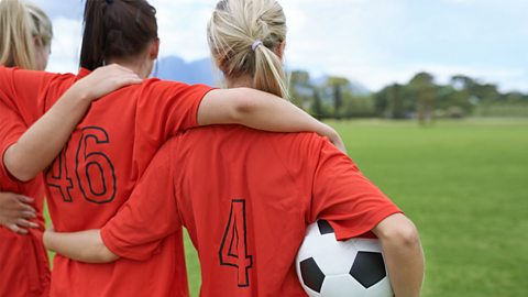 Female football team huddling in a line