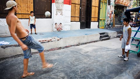 Boys playing football on the street