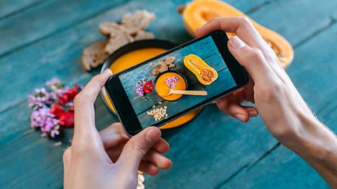 Hands taking a photo of food on mobile phone