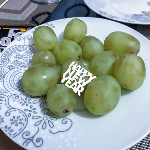 Grapes on a plate with sequin reading Happy New Year