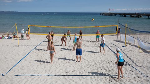 People playing volleyball on a beach