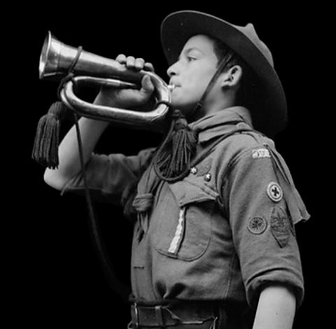 A boy scout sounding the alarm during World War One.