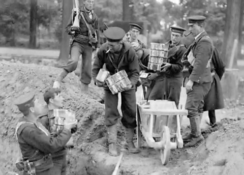 A group of soldiers take supplies into a World War One trench