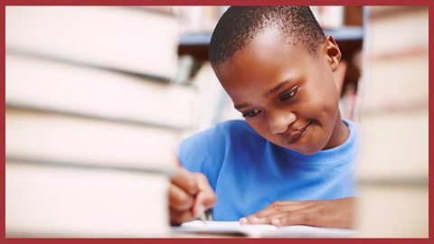 Image: a boy thinking as he writes