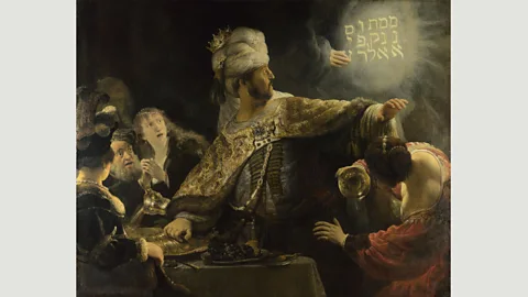 Wikimedia Rembrandt’s Belshazzar’s Feast shows a divine hand inscribing a warning to the king of Babylon after he blasphemously served wine in a looted sacred vessel (Credit: Wikimedia)