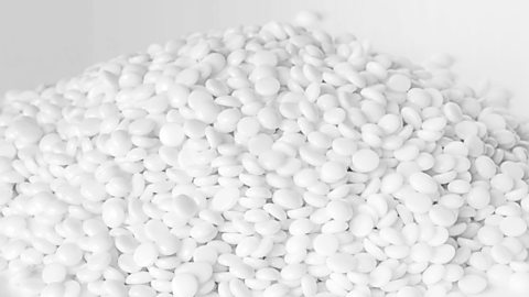 A large heap of fine white thermoplastic granules on a white background.