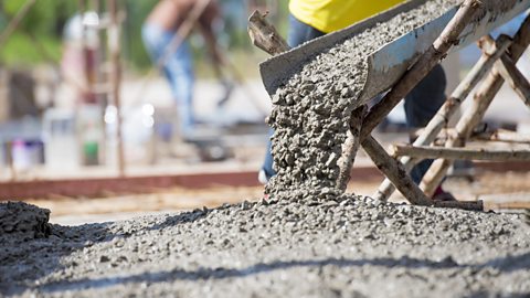 A close-up image of concrete being poured to construct floors of a building.