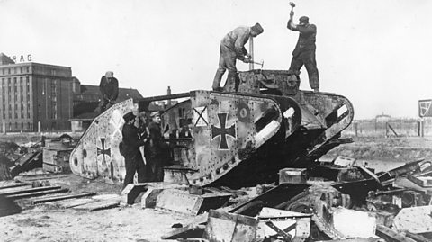 Germans taking a tank apart outside Berlin in 1919 as ordered by the Treaty of Versailles