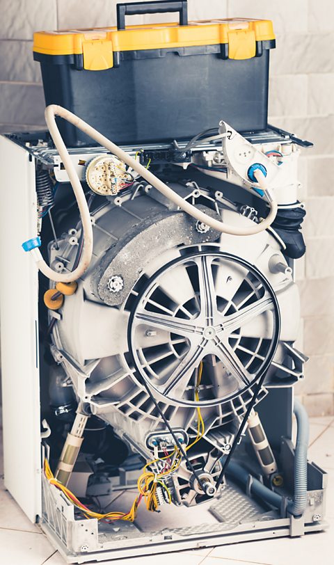 A washing machine with an open enclosure showing all of its parts.