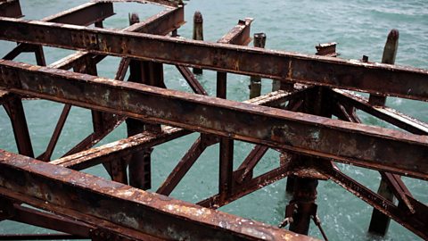 Orange, flaking rust on an old steel pier