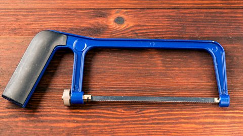 Blue junior hacksaw on wooden bench